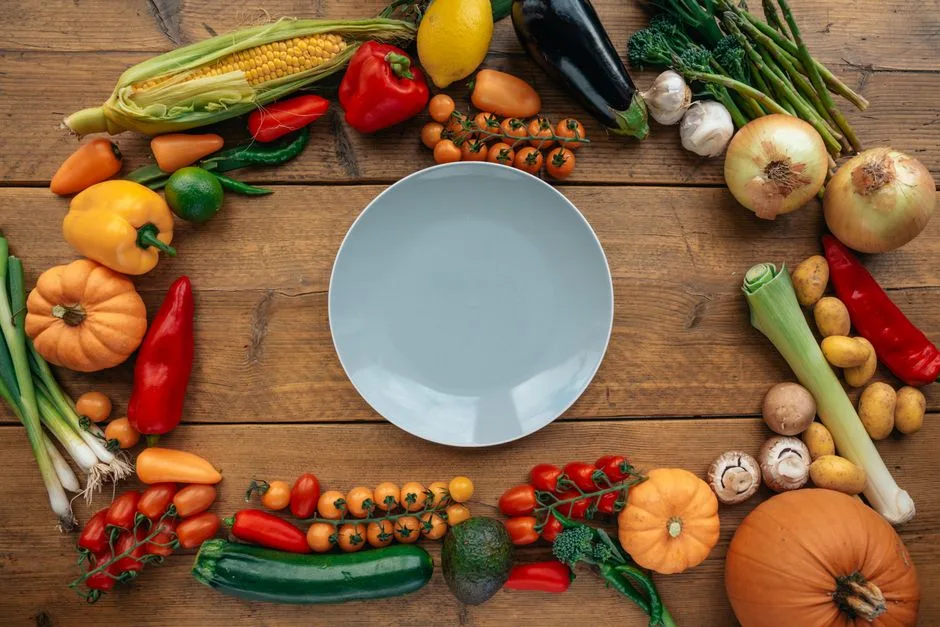 Assiette blanche sur une table en bois entourée de légumes frais et colorés